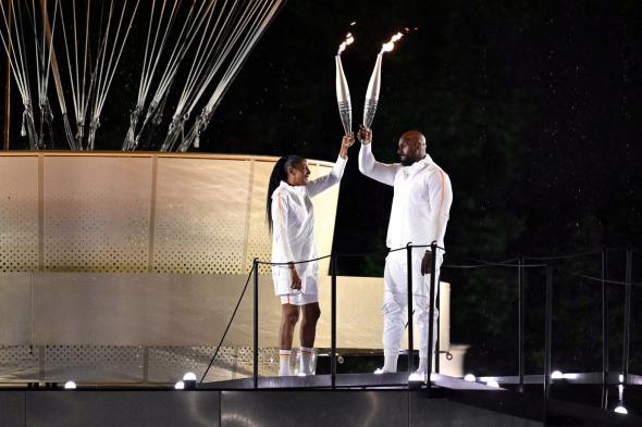 رياضيان بارزان يوقدان المرجل الأولمبي
